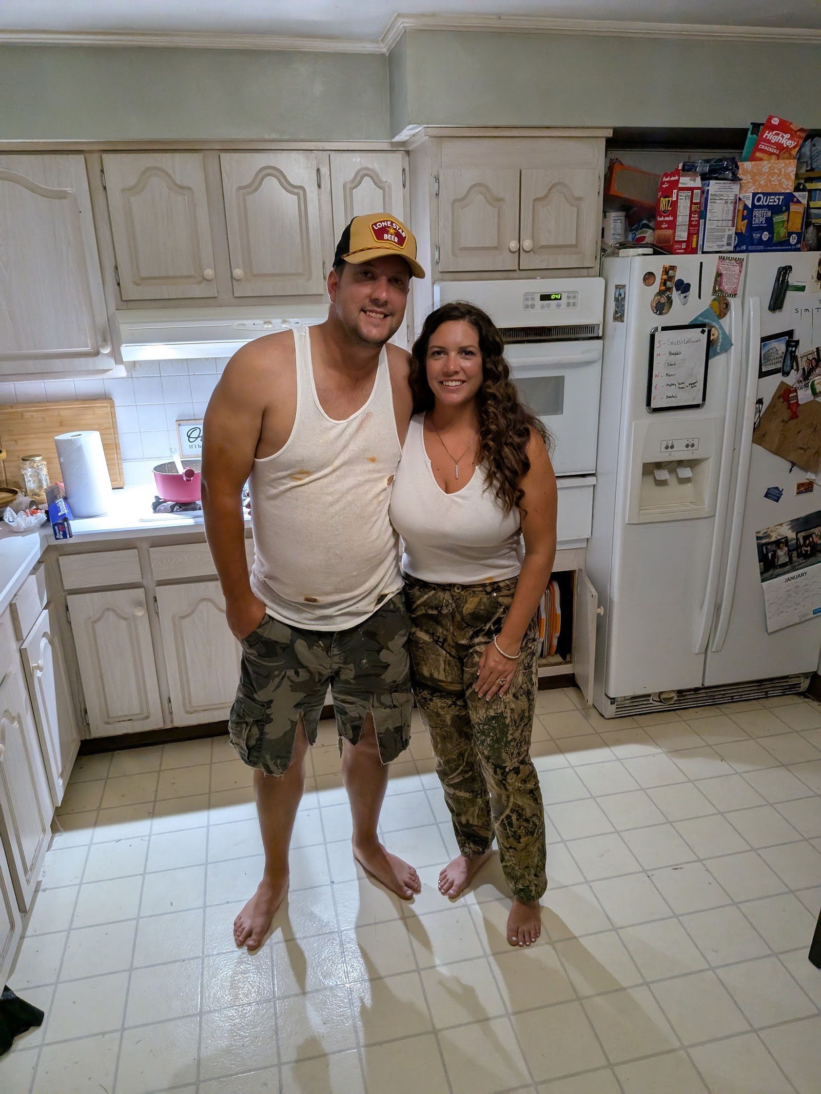 A couple in matching camo and tank tops in the kitchen